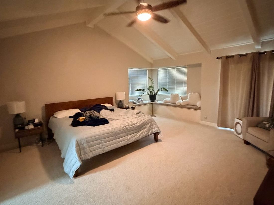 Primary bedroom with vaulted beamed ceiling and bay window seat