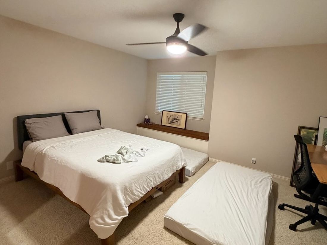 Guest bedroom with queen bed and two floor mattresses already laid out