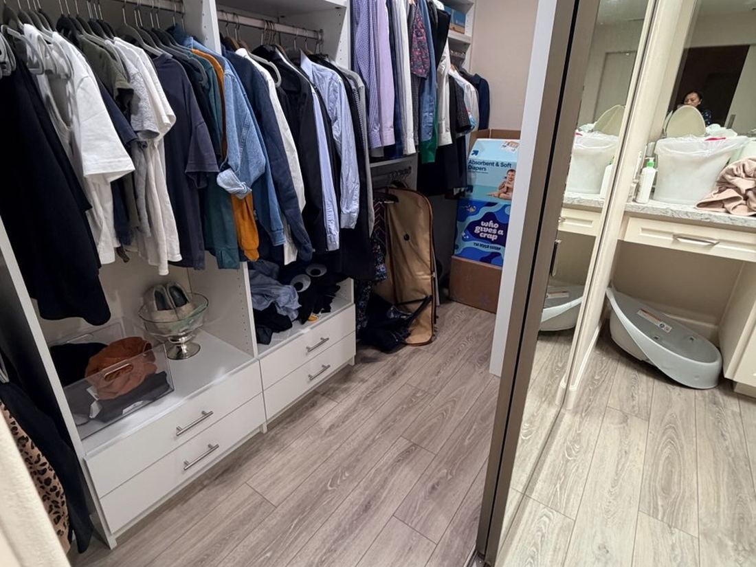 Walk-in closet with built-in shelving, opening onto a vanity area